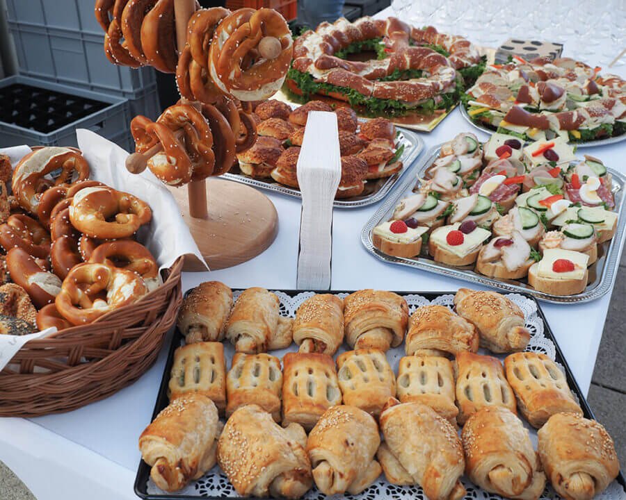 Reichhaltiges Buffet mit Brezeln, belegten Brötchen und Blätterteiggebäck auf einem Hochzeitsempfang