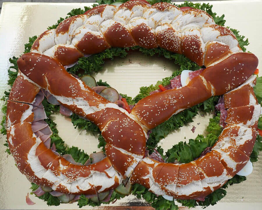 Große Brezel belegt mit Aufschnitt, Käse und Salat